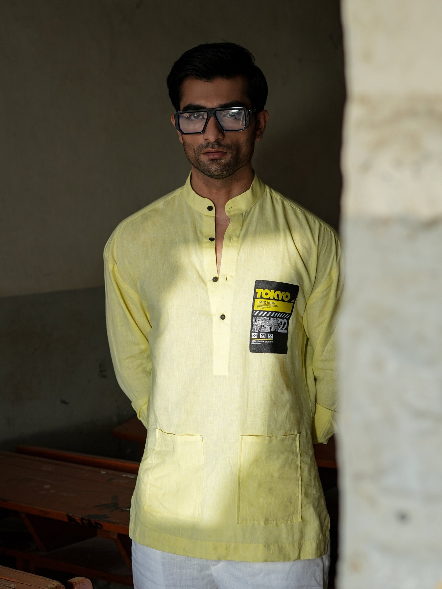 Man wearing a light green shirt with a brand label in an indoor setting