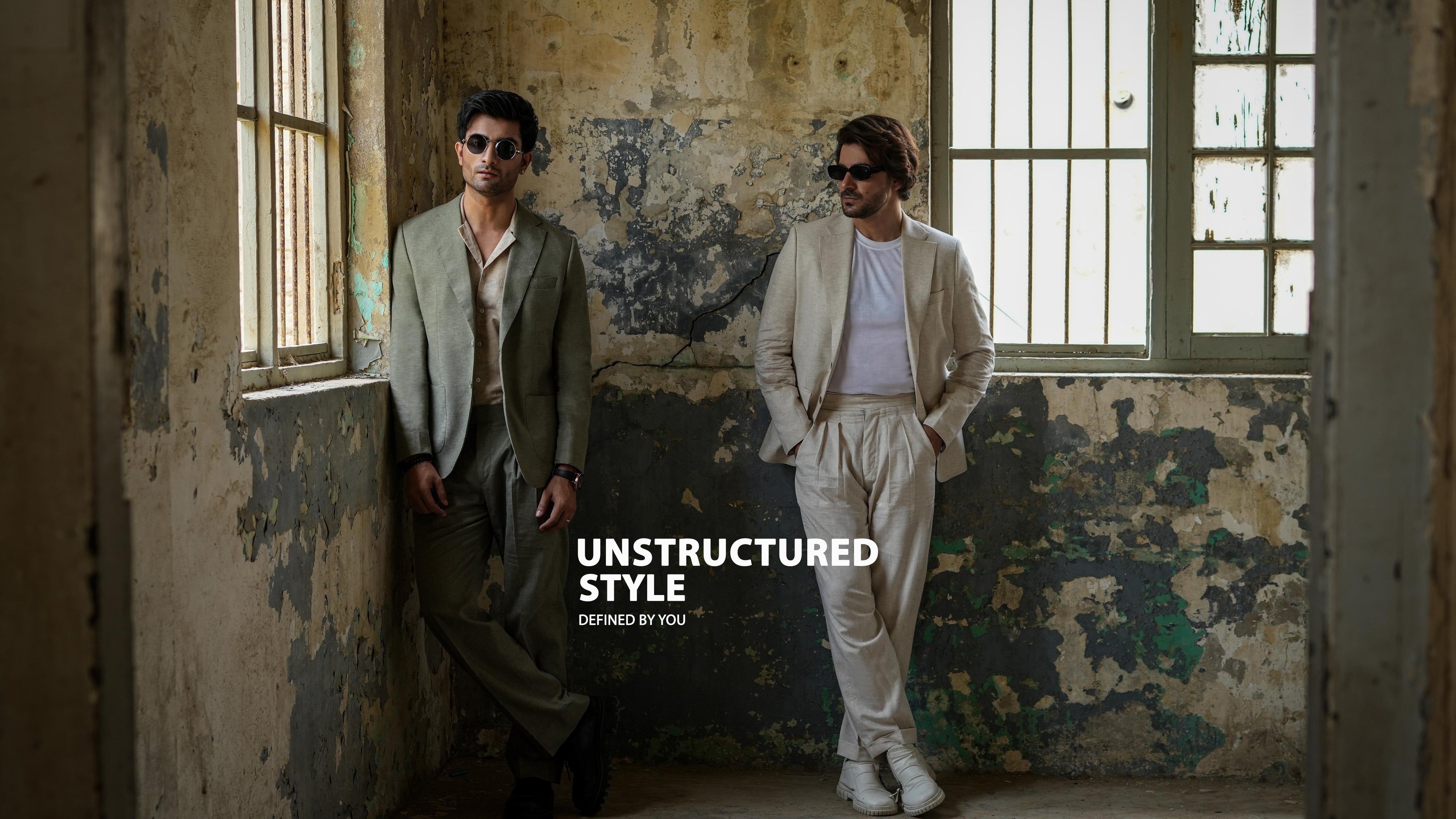 Two individuals in stylish outfits standing in an abandoned building with 'Unstructured Style' text.